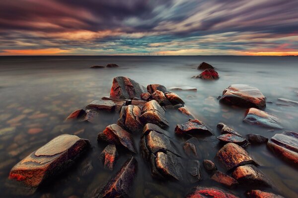 Pietre nel mare al tramonto in Svezia