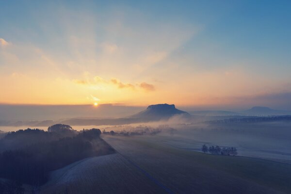 Encuentro del amanecer con la niebla sobre las montañas y el horizonte