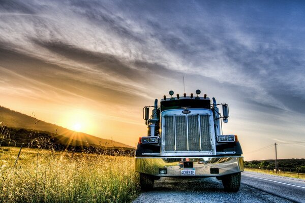 Camion sul ciglio della strada vicino al campo durante il tramonto