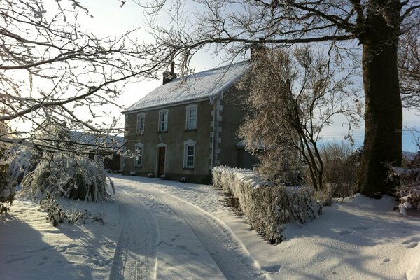 Paesaggio invernale con casa sulla strada