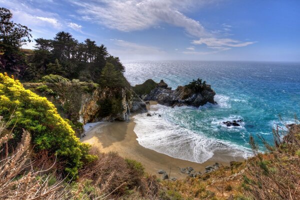 The warm water of the ocean beats against the rocks