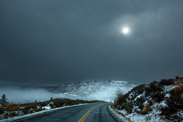 Strada invernale deserta sotto la luna fredda