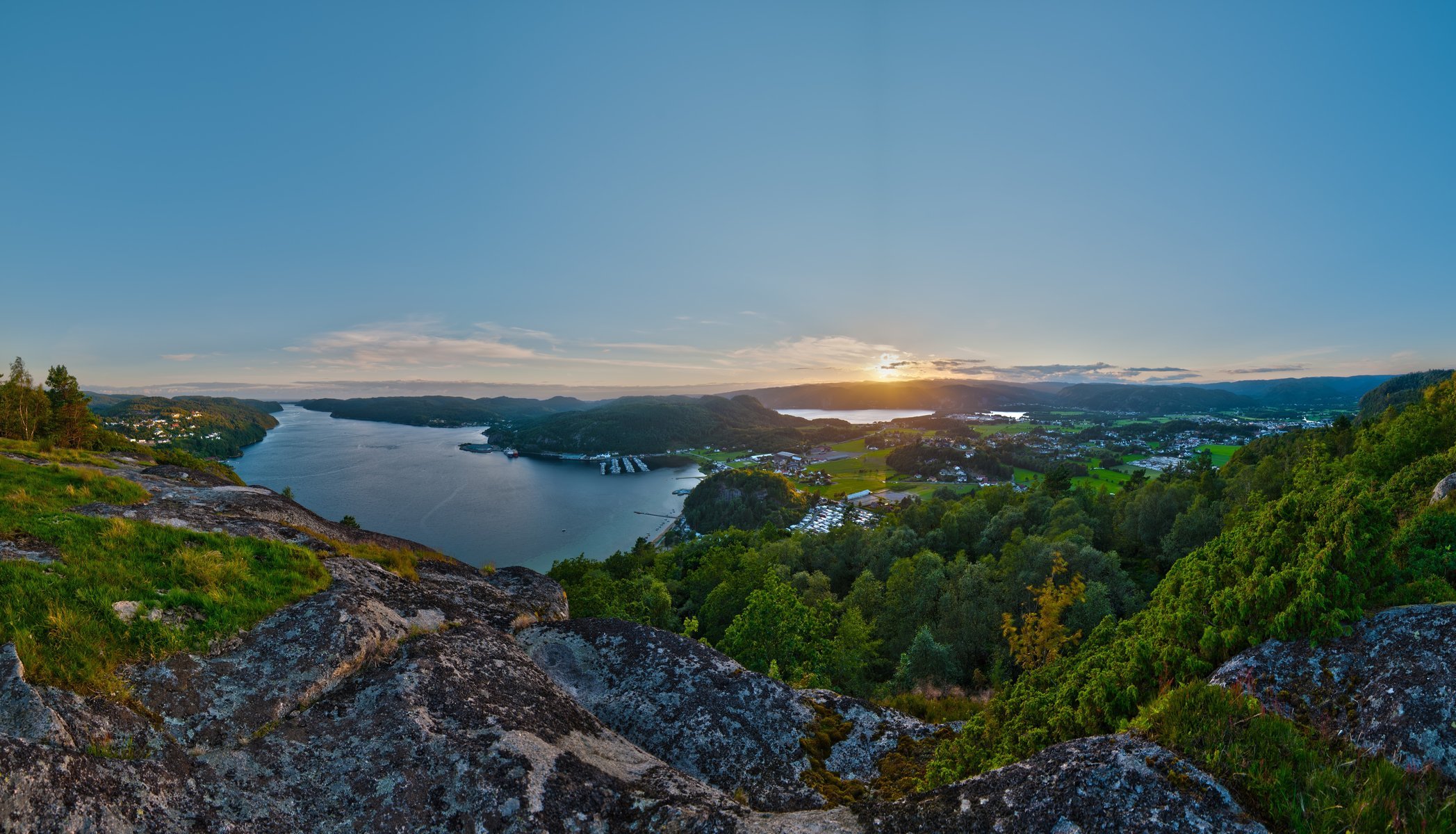 vista paisaje panorama bahía mar barcos piedras vegetación ciudad casas puesta de sol