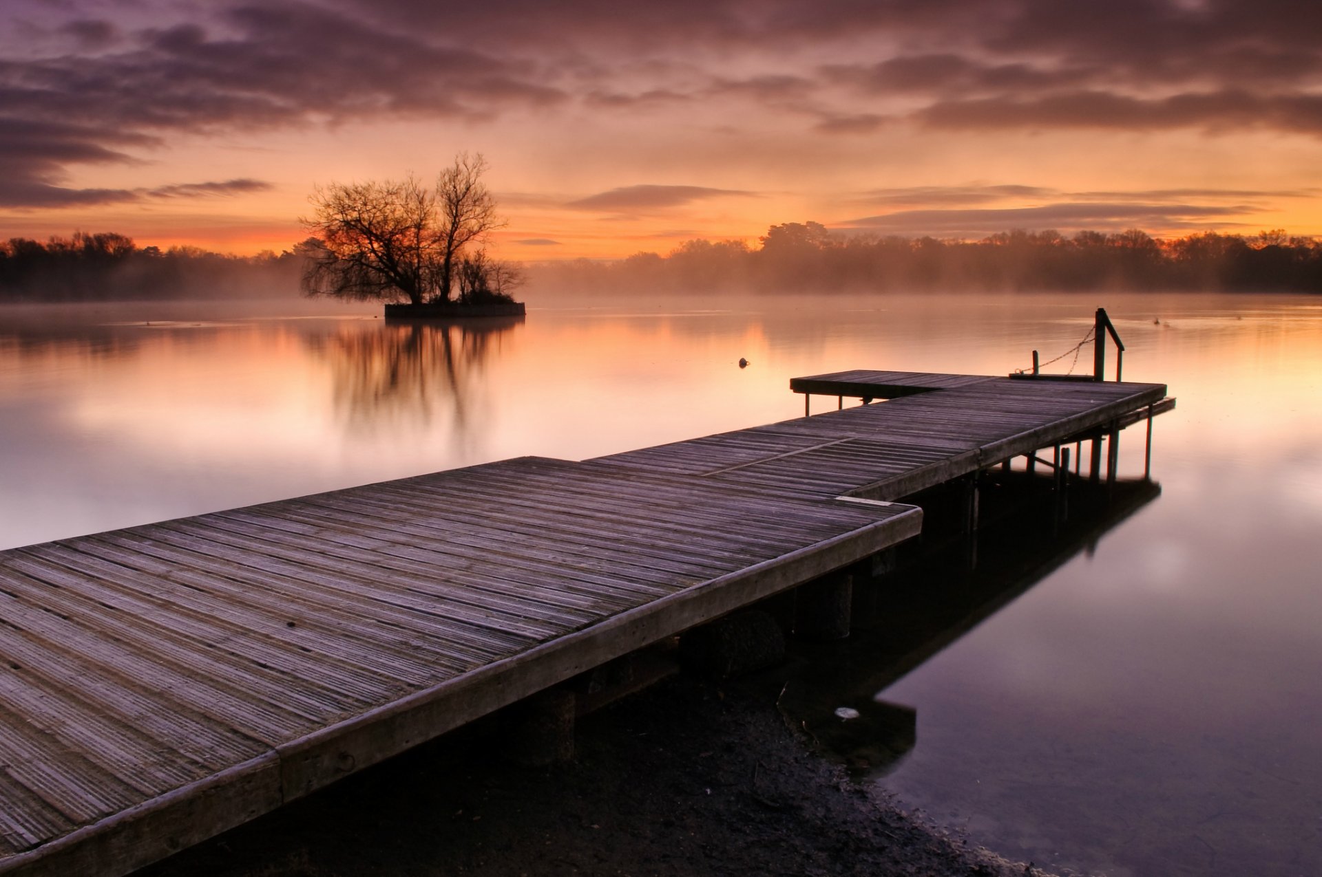 regno unito inghilterra lago acqua superficie liscia foschia evaporazione nebbia alberi legno ponte sera arancione tramonto cielo nuvole