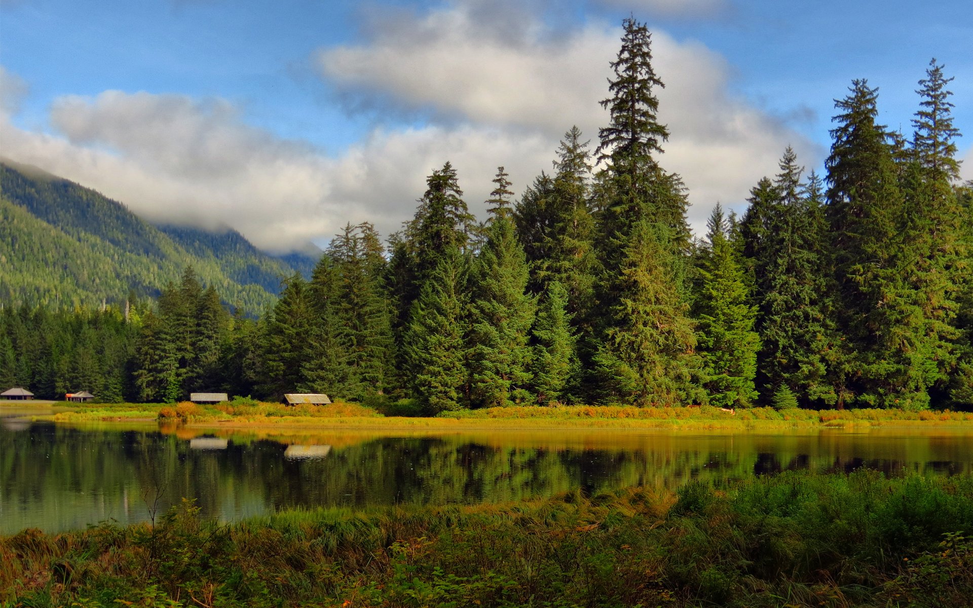 lac forêt arbres maisons bâtiments collines surface réflexion nuages