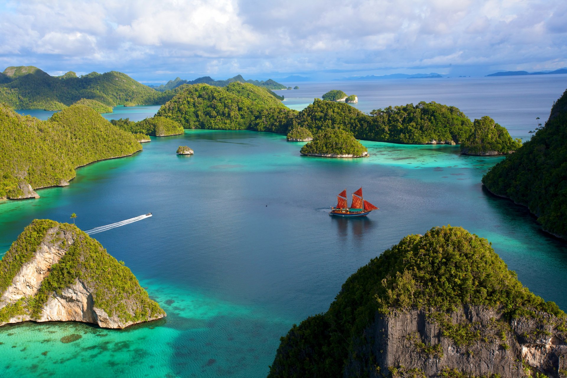 indonesia islands rock stones vegetation lagoon water ship sailboats boat sky cloud