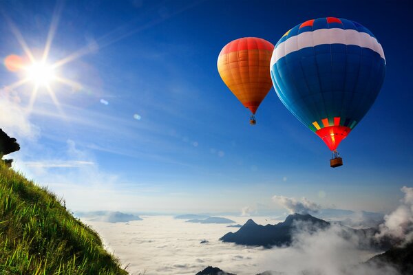 Flying balloons on the background of the sky and the green slope