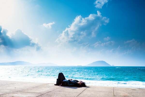 The girl is lying on the seashore