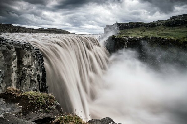 Landschaft macht einen Wasserfall bei bewölktem Wetter