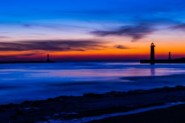 Ein See mit einem Leuchtturm in Michigan vor dem Hintergrund eines hellen Sonnenuntergangs