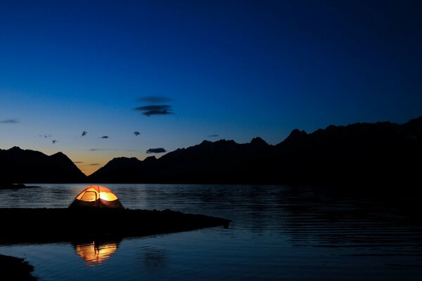 Landscape of the lake in the dark with a tent