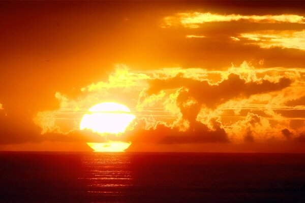 Naranja puesta de sol en el mar entre las nubes