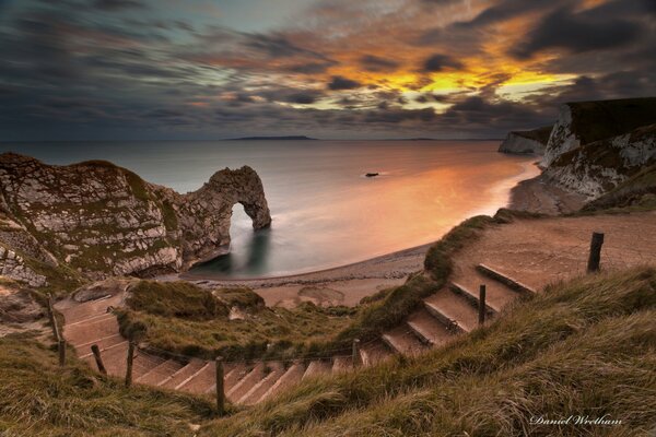 Escalera al mar y arco al atardecer