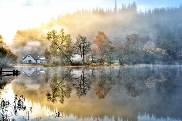 Herbstbäume am See und am weißen Haus