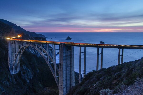 Pink sunset over California. Bridge in the mountains