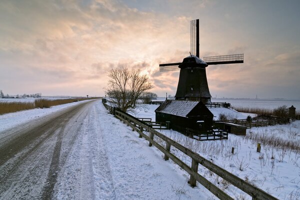 Molino en el fondo de la puesta de sol de invierno