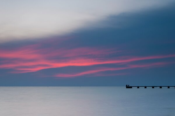 Pier on the sea with evening sunset