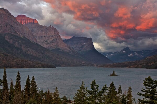 Nuages roses sur le lac dans les montagnes