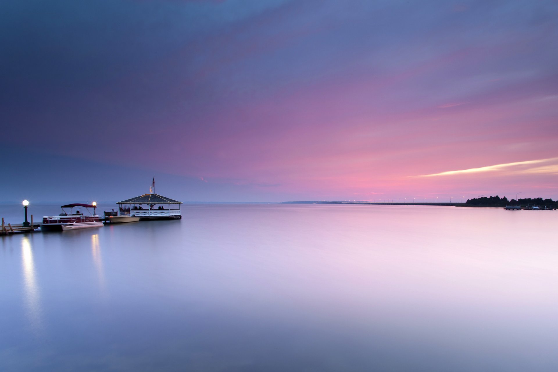 united states ocean water surface of calm pier lamps boat night sunset