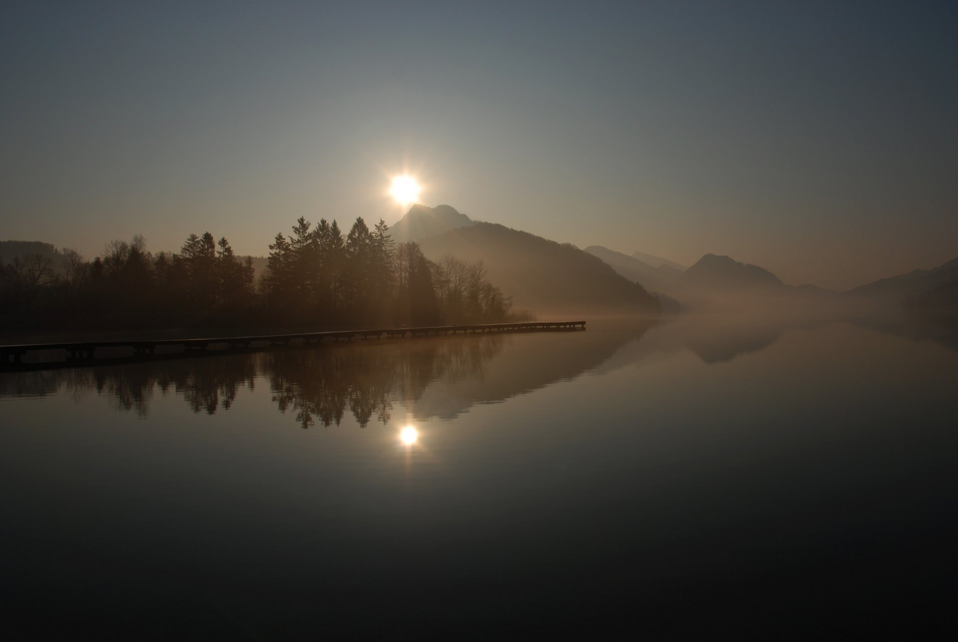 liegeplatz steg pier see oberfläche reflexion hügel nebel bäume morgen sonne sonnenaufgang