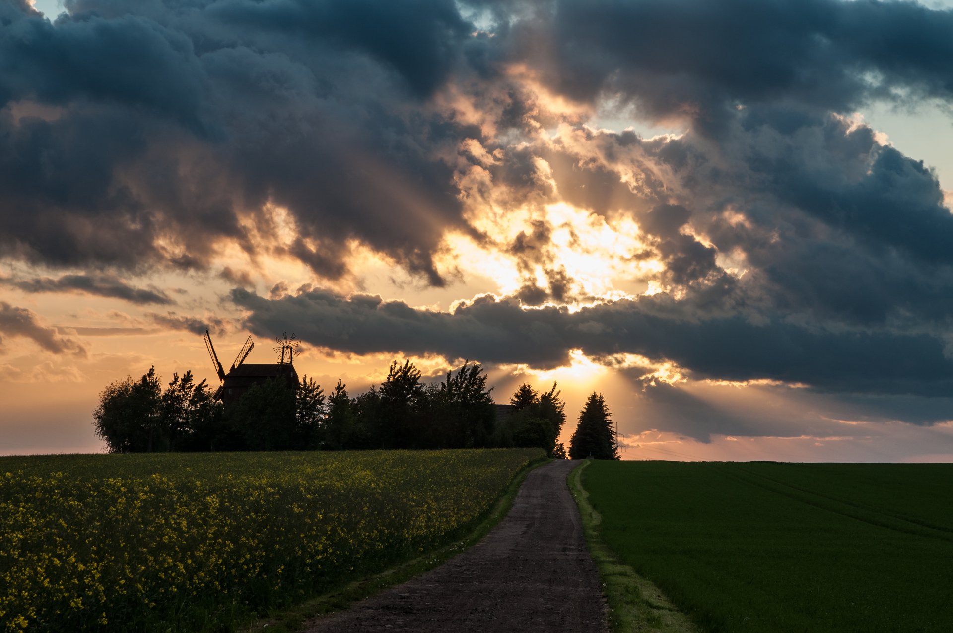 road sky clouds rays sun mill the field rapeseed