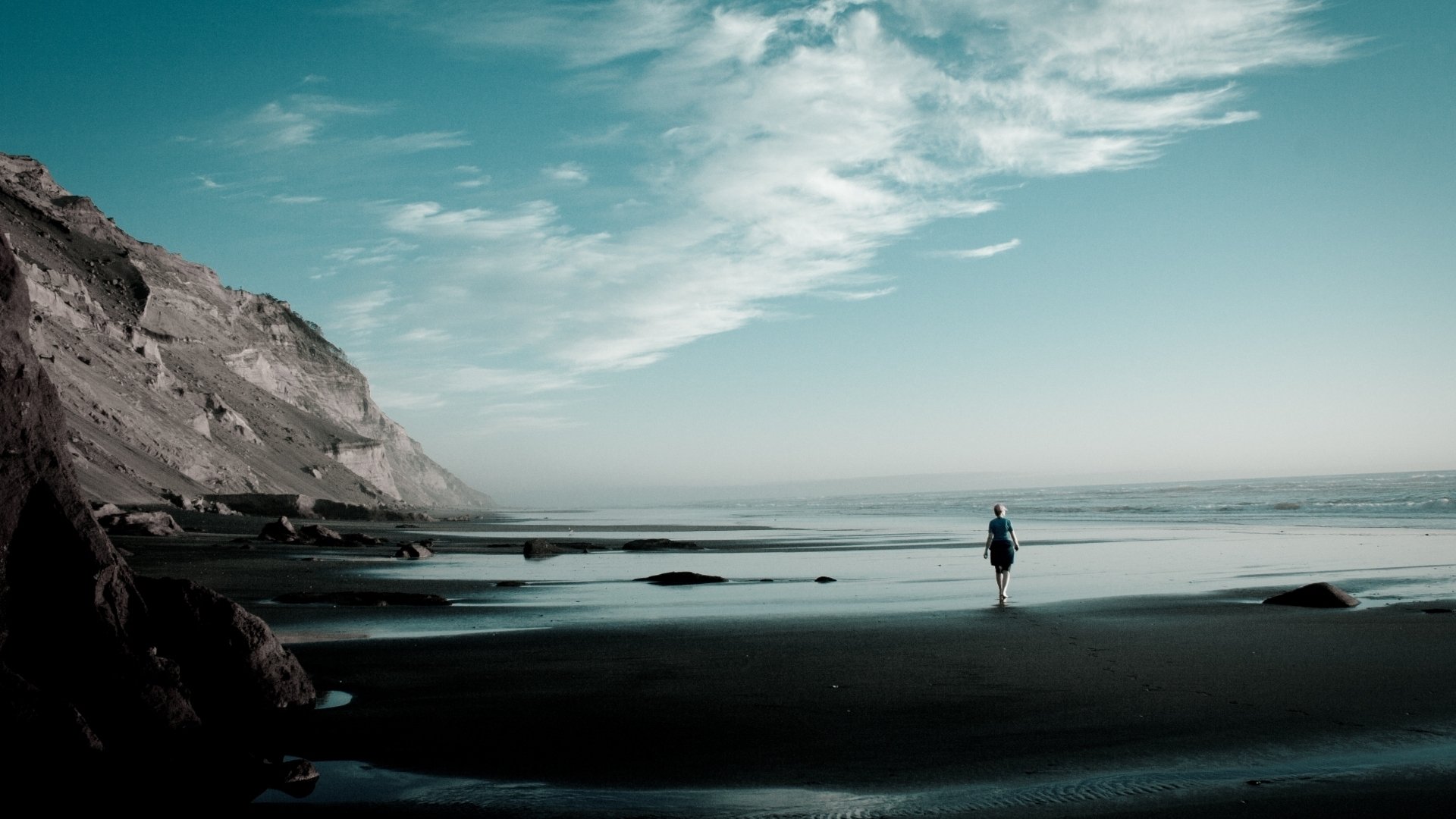 ea ocean beach coast sand mountain slope stones girl horizon sky clouds wave