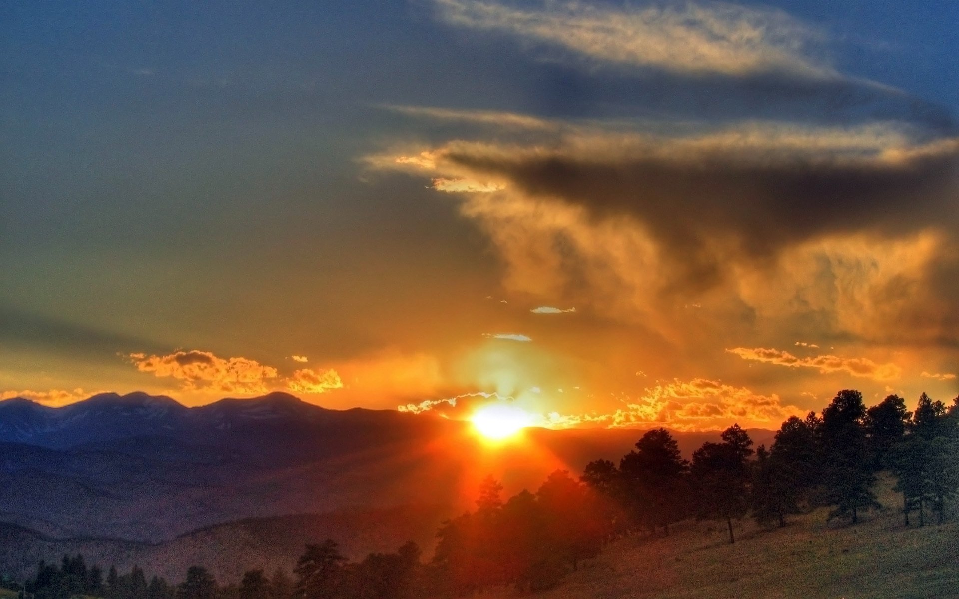 forest trees slope mountains hills horizon silhouettes sky clouds sun light rays sunset cloud