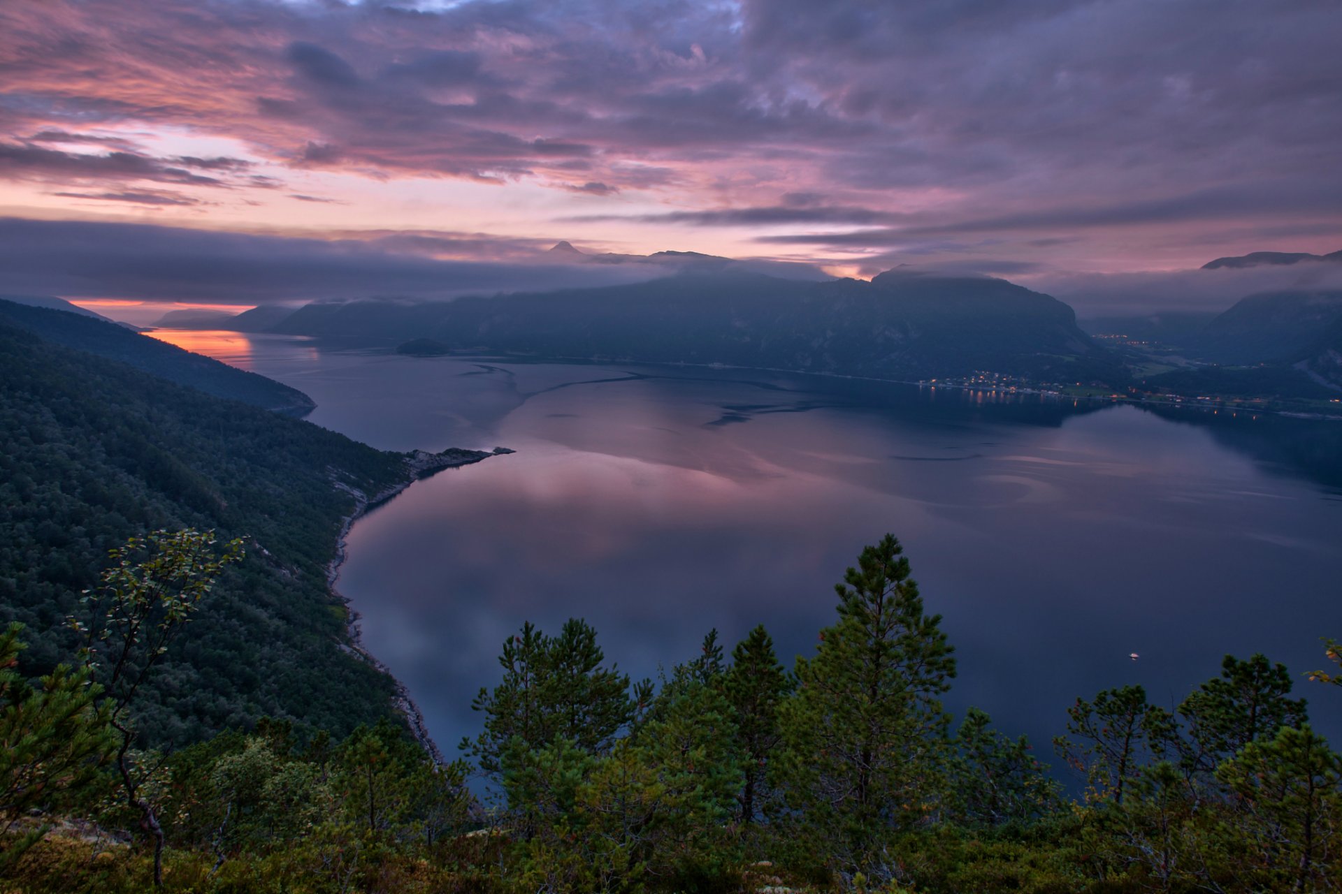 noruega naturaleza fiordo montañas árboles lago tarde puesta de sol cielo nubes ciudad luces vista altitud panorama