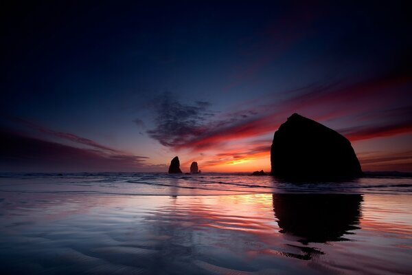 The sea at sunset with silhouettes of rocks