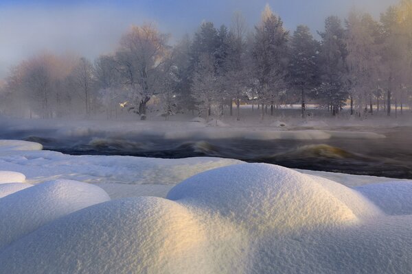 Winter landscape with rounded snowdrifts and frosted trees