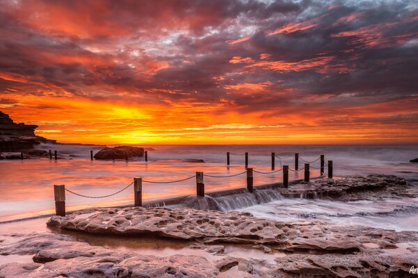 Puesta de sol malinovy. Muelle y piedras