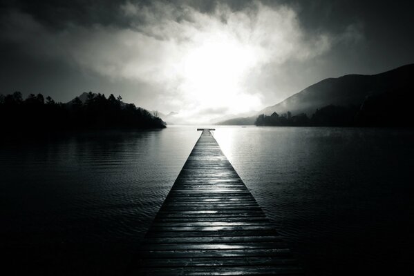 Pier on the lake among the fog and trees