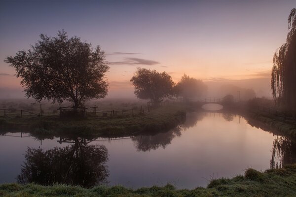 Einfache rustikale Landschaft mit Fluss und Morgennebel