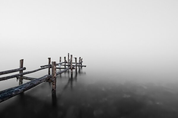 Foggy morning. Bridge over the lake