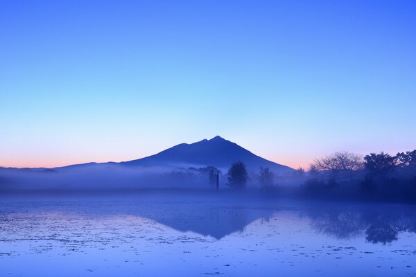 Riflesso del cielo blu della sera e della montagna