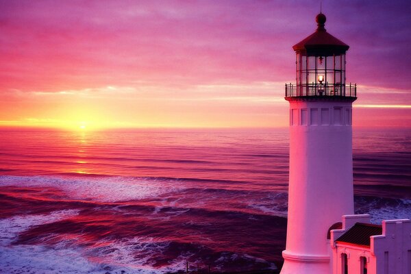 A lonely lighthouse at sunset by the sea