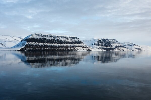 Beautiful snowy mountains are reflected in the water