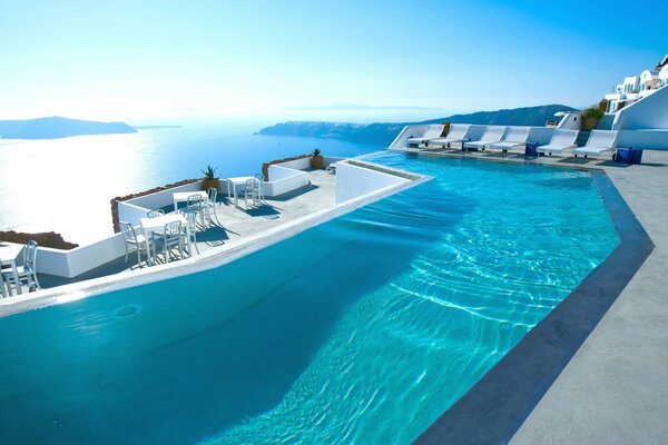 In santorini, a hotel room with a swimming pool overlooking the sea