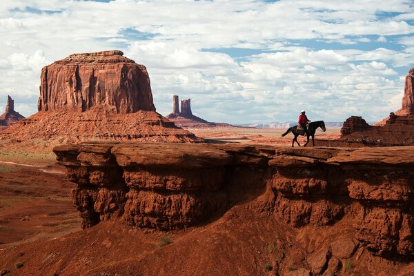 Cowboy rides a horse in Monument Valley