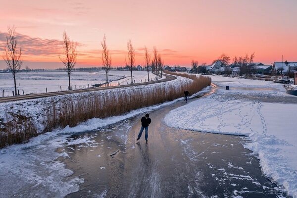 Eislaufen auf einer vereisten Straße bei Sonnenuntergang