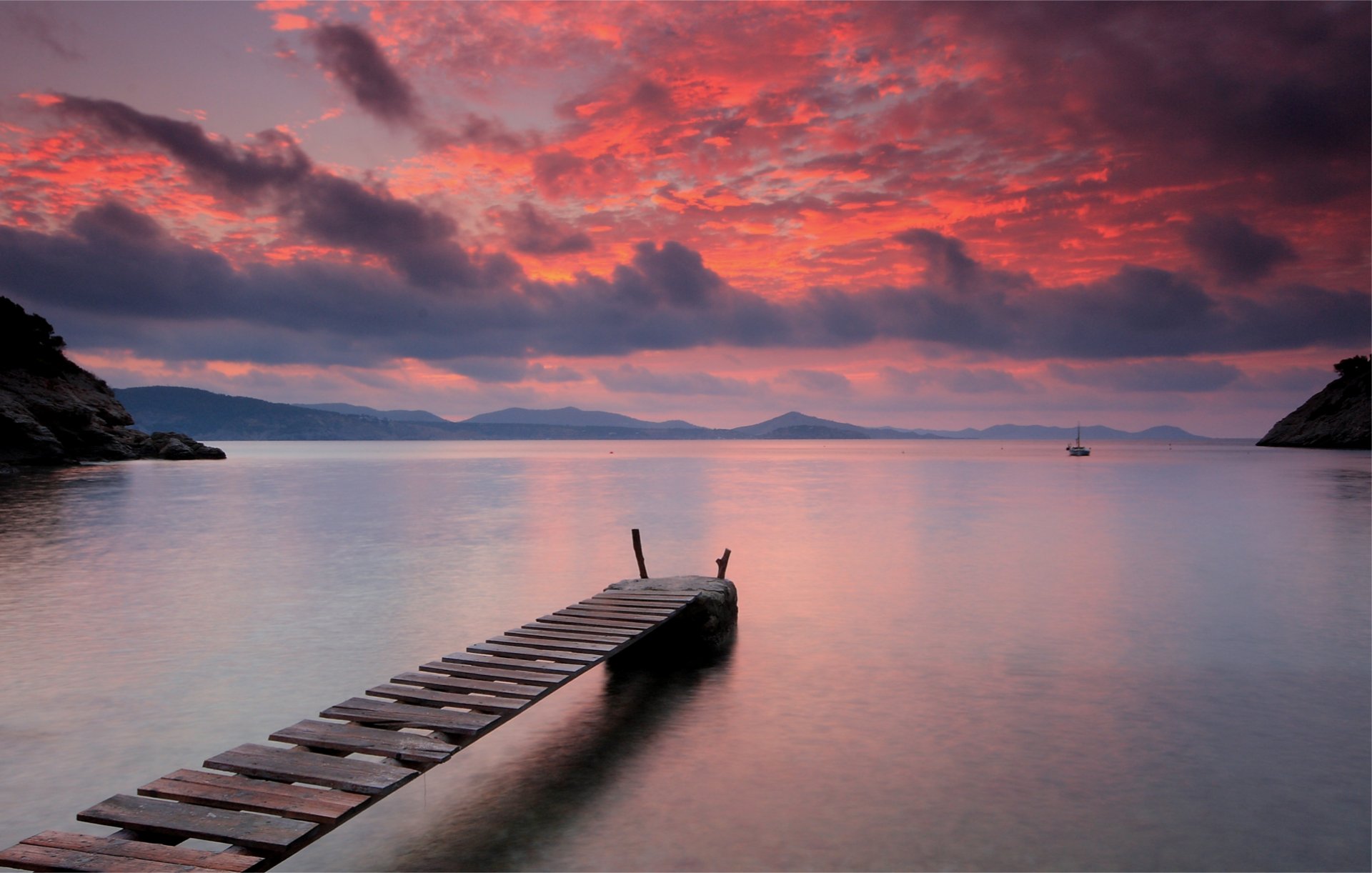 sera lago acqua superficie liscia silenzio legno ponte luminoso arancione tramonto cielo nuvole montagne vela lontano