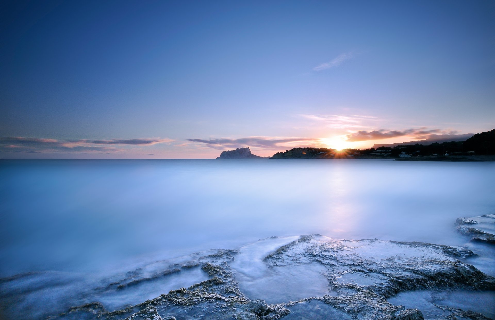 mare oceano costa acqua superficie liscia blu cielo nuvole sole luce tramonto sera