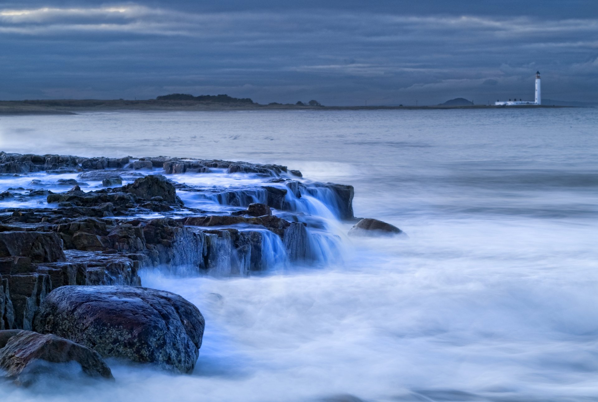 great britain scotland lighthouse shore rocks sea streams surf evening sky clouds far away