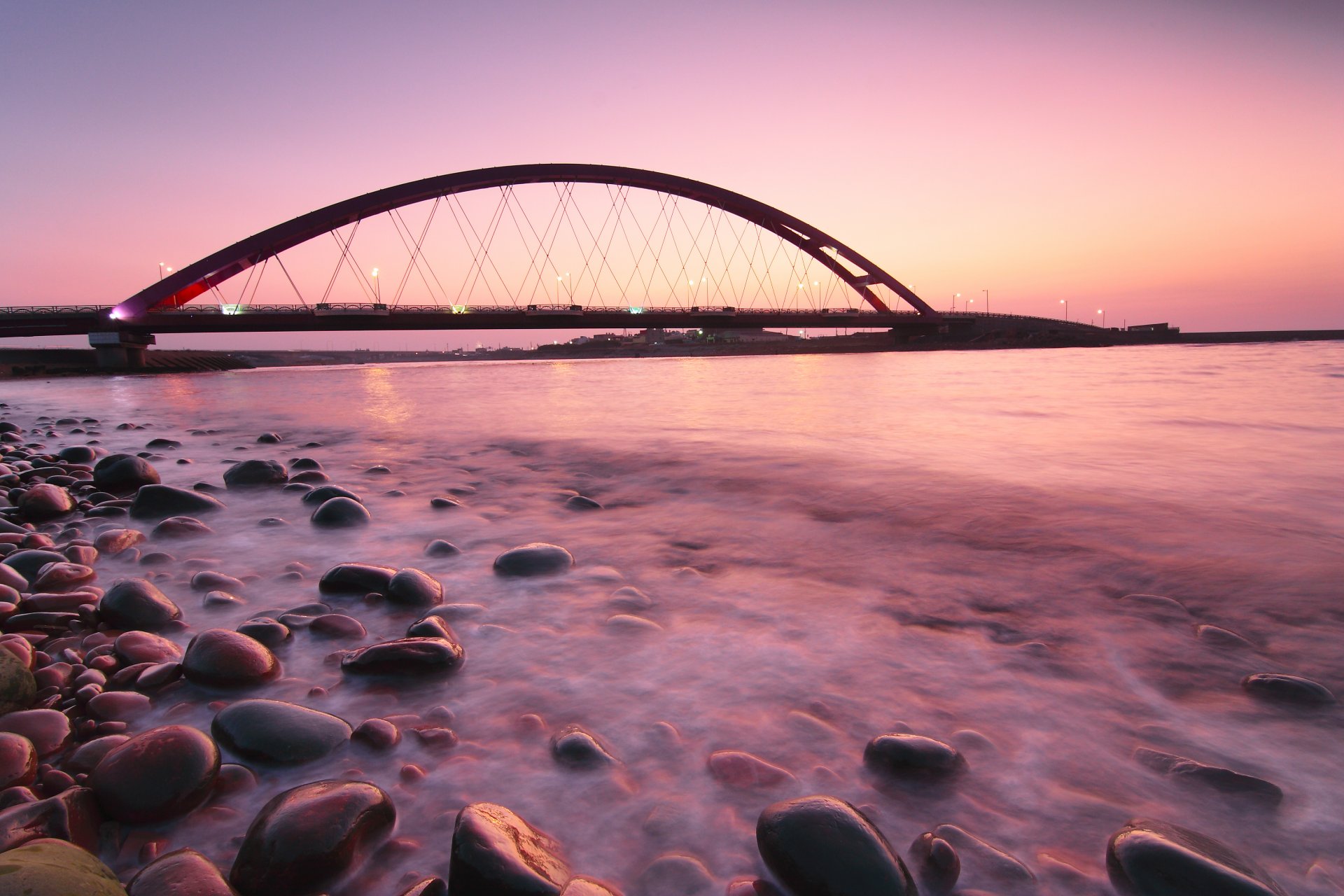 alemania fehmarnsund puente rosa puesta de sol noche puente linternas iluminación mar océano calma costa piedras