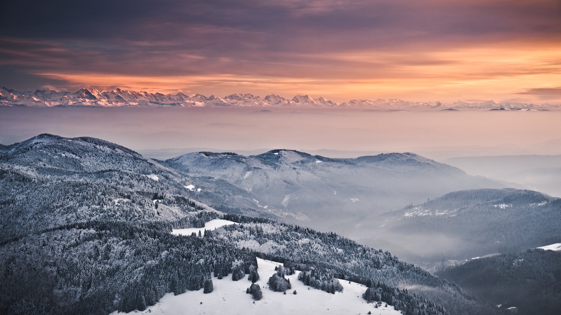 inverno neve montagne alpi colline alberi nebbia sera cielo arancione tramonto vista altitudine panorama