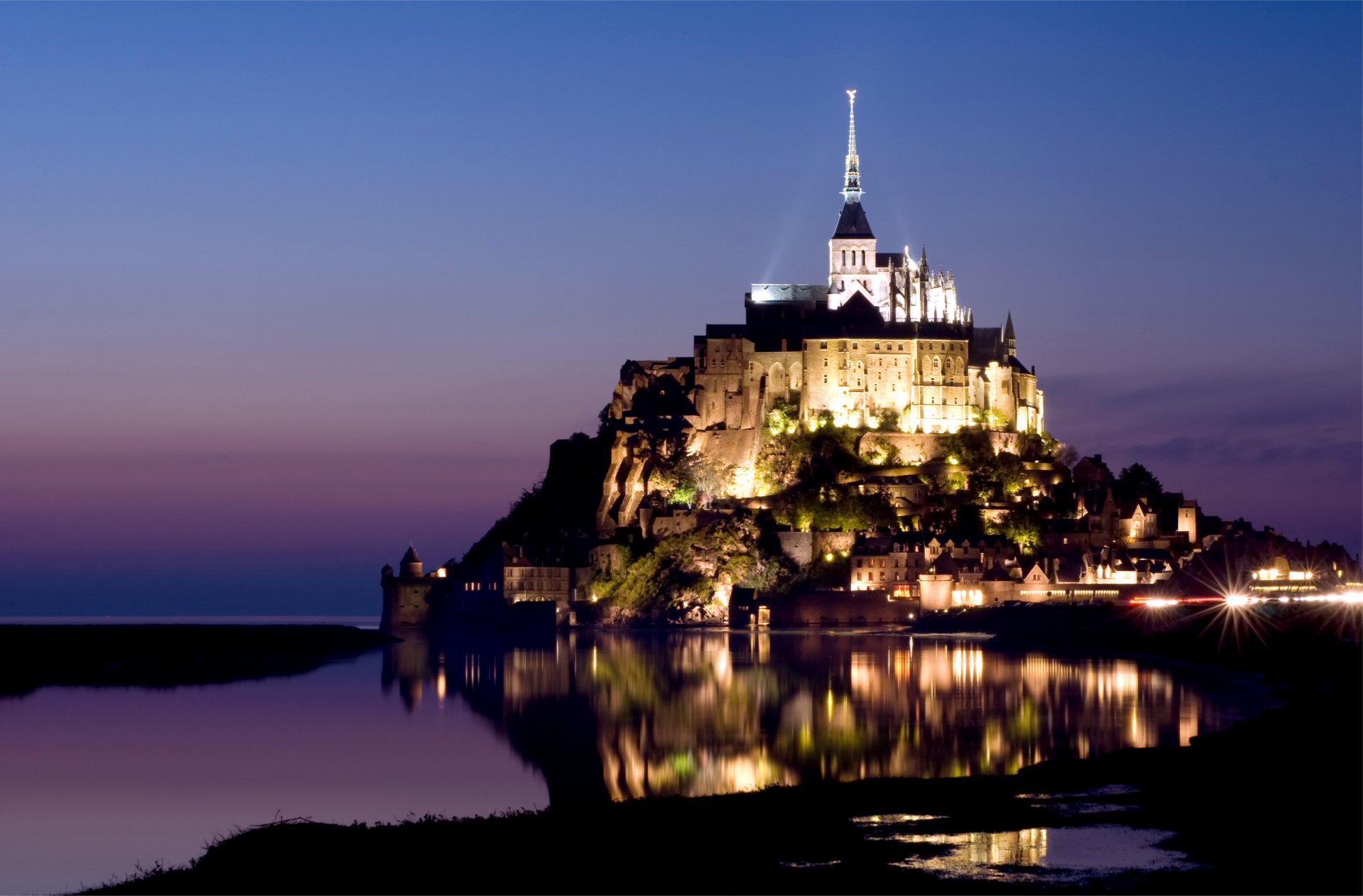 francja normandia mont saint michel wyspa zamek mont saint michel twierdza światła podświetlenie góra archanioła michała liliowy wieczór niebieski niebo woda odbicie