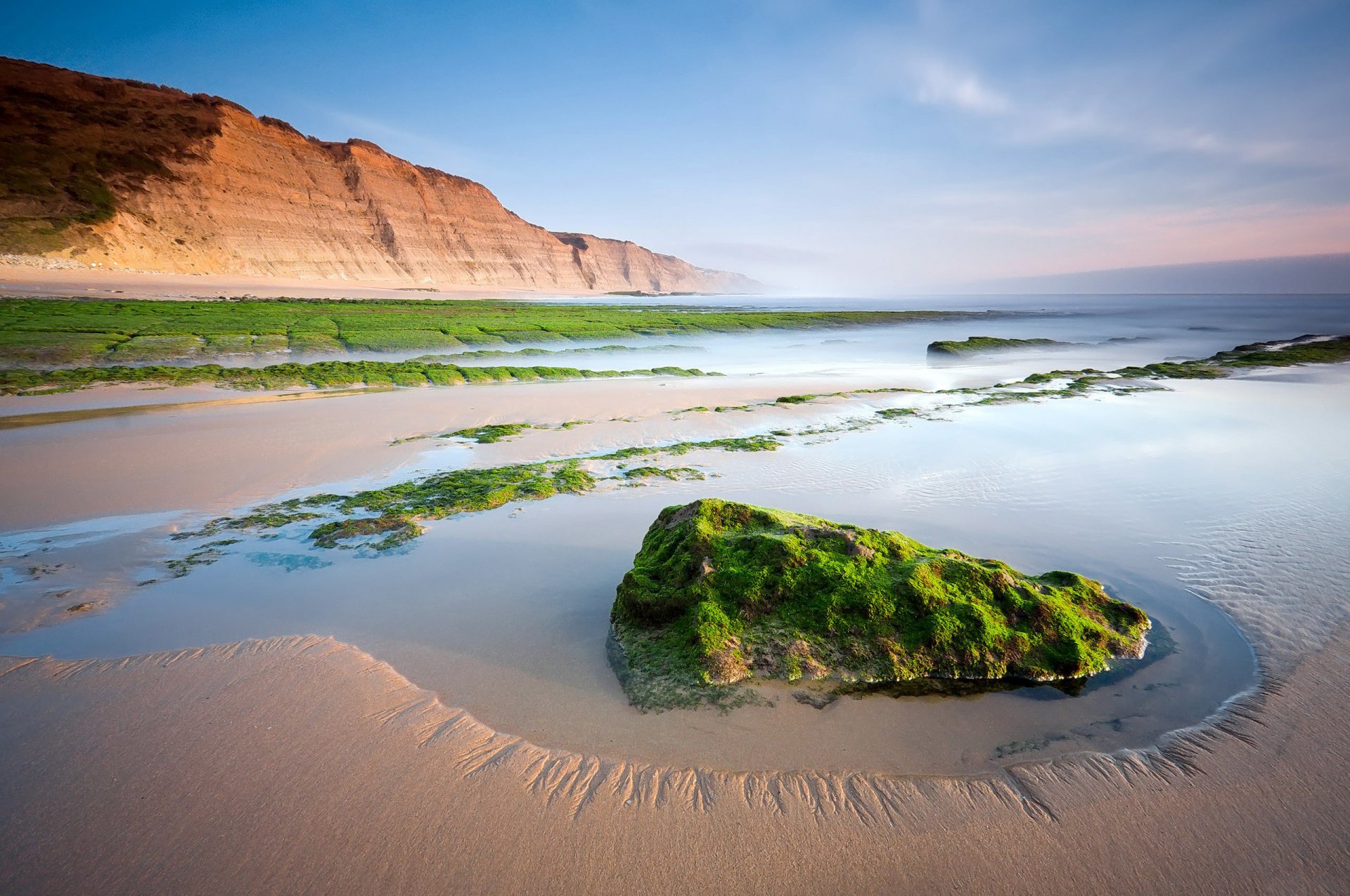 ocean beach mountain stones rock reefs algae sand coast the distance horizon sky