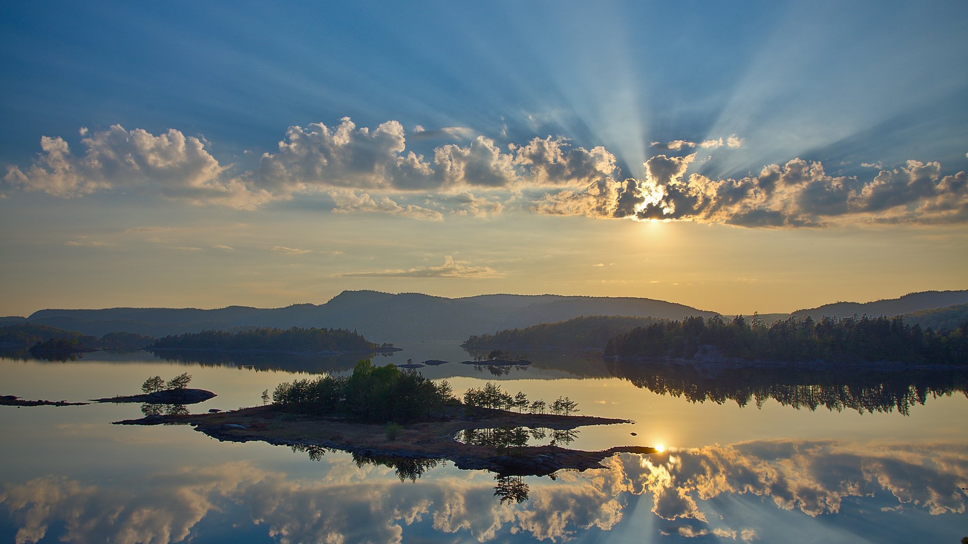 montagnes rivière forêt arbres ciel nuages soleil rayons lumière îles îlots surface réflexion miroir beauté