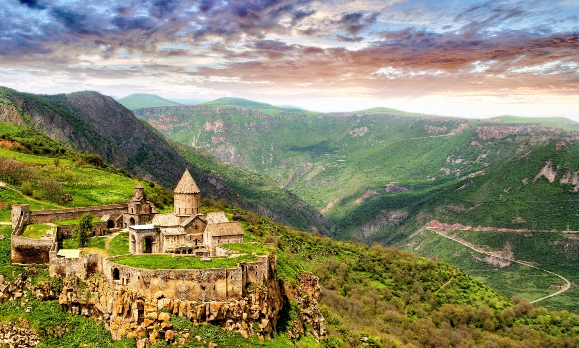 montagnes collines verdure herbe forteresse temple distance horizon ciel nuages maçonnerie