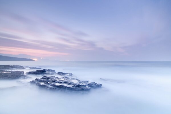 Alba nebbiosa sulle rocce nell oceano